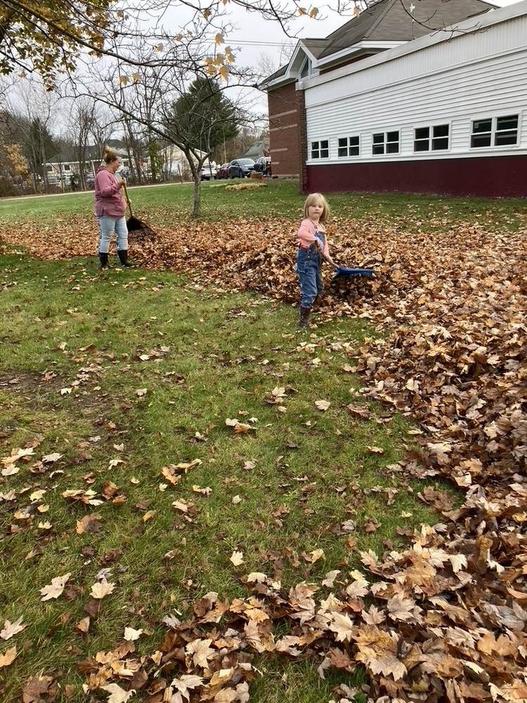 Mom and daughter Novack raking school lawn